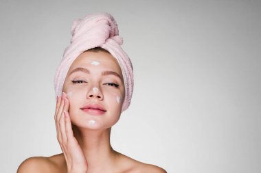 Kadın krem yüz duş sonra başında havlu ile