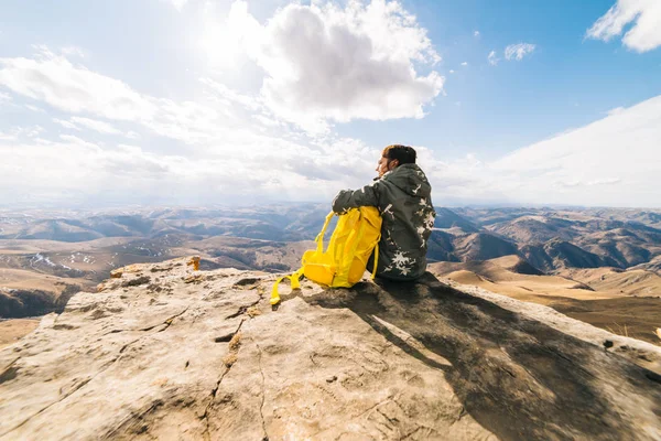 Женщина турист с большим рюкзаком сидит на фоне гор — стоковое фото