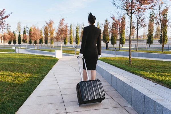 woman in flight stewardess carries a suitcase