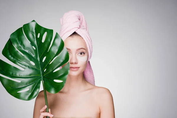 Mujer feliz con una toalla en la cabeza después de la ducha ha puesto parches bajo los ojos — Foto de Stock