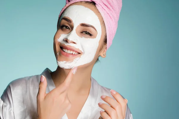 Mujer feliz con una toalla en la cabeza después de ducharse la máscara en la cara —  Fotos de Stock