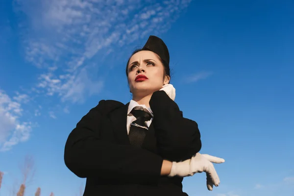 Donna hostess in uniforme sta su sfondo cielo — Foto Stock