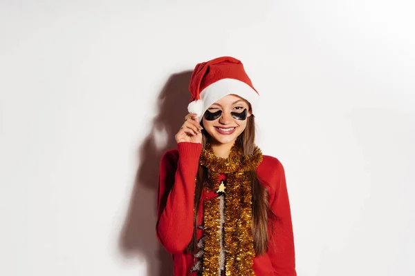 Glückliche Frau im Neujahrsanzug legt Pflaster unter die Augen — Stockfoto