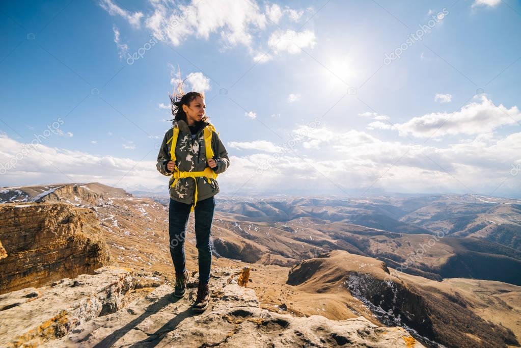 woman tourist standing against a high mountain background