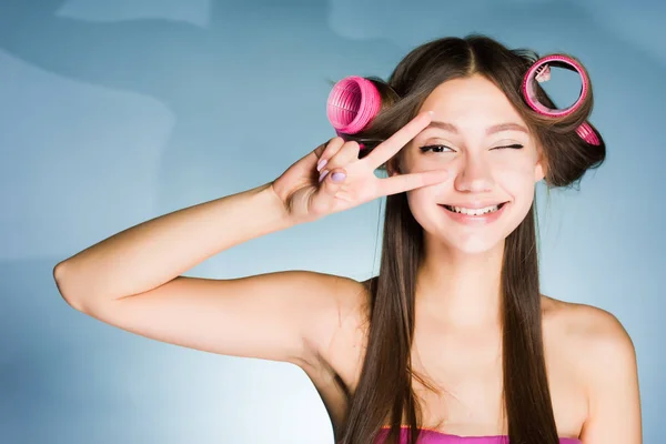 Счастливая улыбающаяся девушка, показывающая два пальца на голове керлингиста — стоковое фото