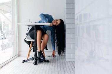 genç kız aşağı eğilerek bir kafede bir masada oturan mavi gömlekli