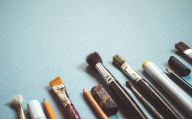 mavi bir tabloda farklı boyutlarda birçok Sanat fırçalar vardır