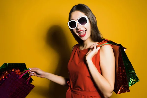 Glückliches Mädchen in rotem Kleid und Sonnenbrille ging shoppen — Stockfoto