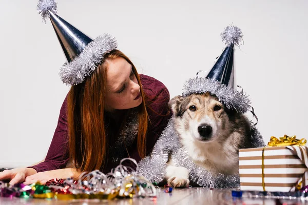 Woman in holiday cap sitting with dog — Stock Photo, Image