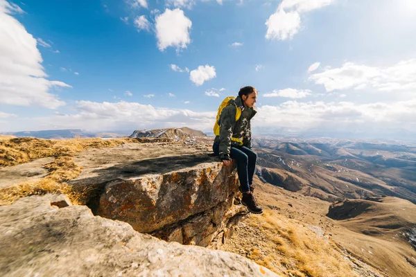 Kadın turist büyük sırt çantası ile dağlar arka plan üzerinde oturur — Stok fotoğraf