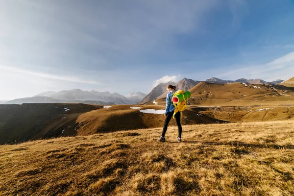 Жінка туристка з великим рюкзаком, що стоїть на тлі гір — стокове фото