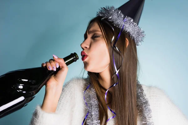Пьяная женщина в праздничной шляпе держит бутылку в руке — стоковое фото