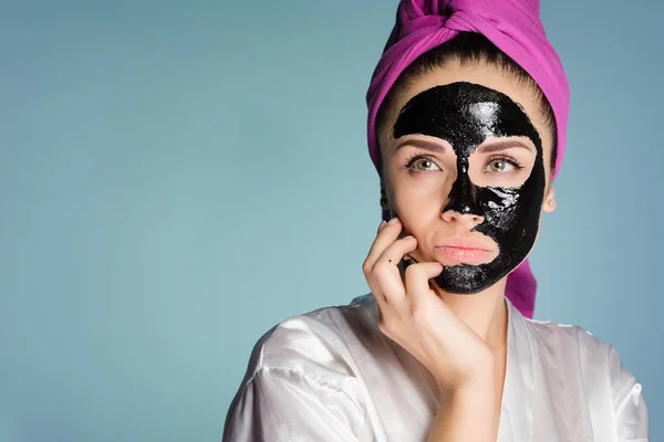 Egy átgondolt nő a fején egy törülközővel alkalmazni a tisztító maszk — Stock Fotó