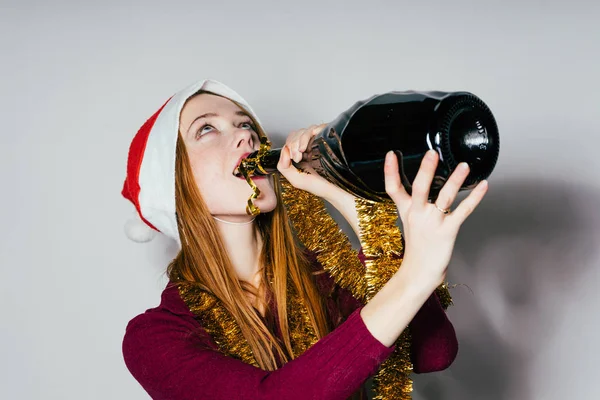 Mulher em um traje de Ano Novo bebe champanhe de uma garrafa — Fotografia de Stock