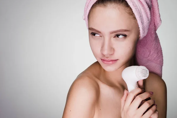 Woman with towel on her head after shower holding a brush for deep cleaning — Stock Photo, Image