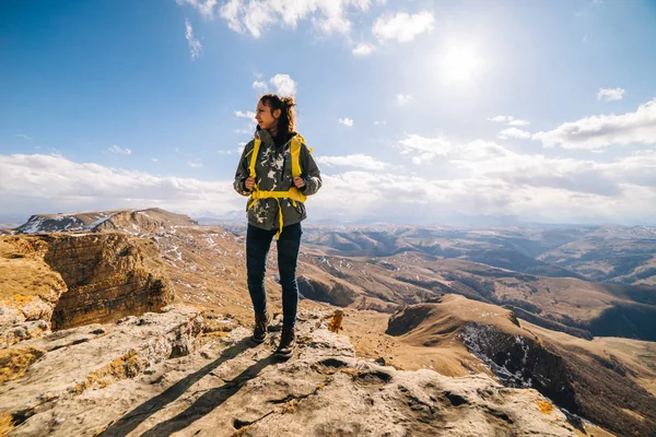 Жінка-турист стоїть на тлі високих гір в сонячний день — стокове фото