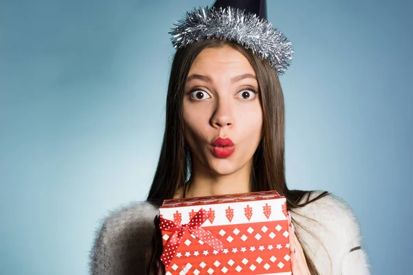 Mujer sorprendida en un sombrero festivo tiene un regalo en sus manos —  Fotos de Stock