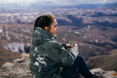 kadın turist Dağları arka plan üzerinde sıcak çay içer