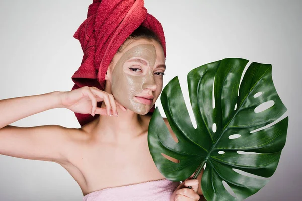 Une femme avec une serviette sur la tête a mis un masque sur son visage et regarde dans la caméra — Photo