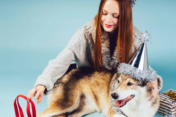 Femme heureuse dans un chapeau festif étreint un gros chien — Photo