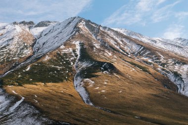 mavi bir gökyüzü altında kar beyaz yüksek görkemli dağlar