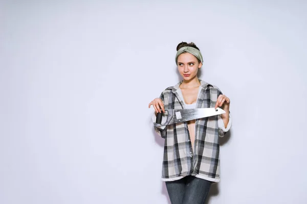 Cute young girl holding a saw and thinking about repairing the apartment — Stock Photo, Image