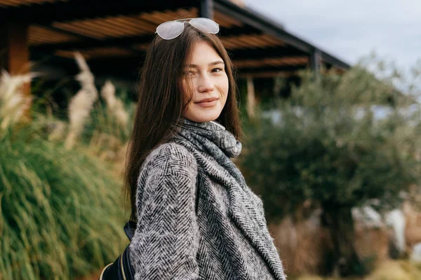 Elegante ragazza alla moda in cappotto grigio passeggiando nel parco, posa e sorridente — Foto Stock