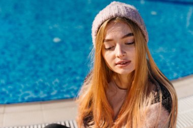 genç çekici sarışın kız havuz başında güneş poz