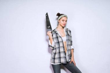 keskin bir testere onun elinde tutan çekici kızı dairede tamirat yapmak istiyor