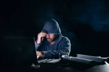 gizemli sakallı adam yüzünü başlık altında gizler, laptop kesmek