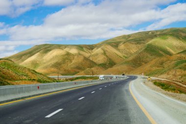 dağlar ve tepeler, mavi gökyüzü altında yakın uzun bir karayolu