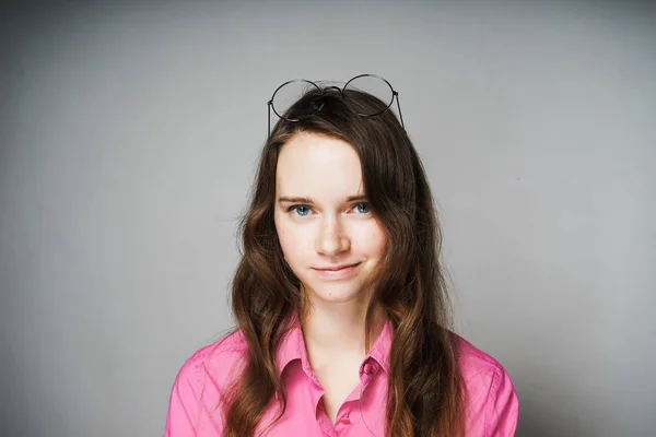 Bonito jovem de cabelos longos menina em uma camisa rosa, estudante do sexo feminino, sorrindo — Fotografia de Stock