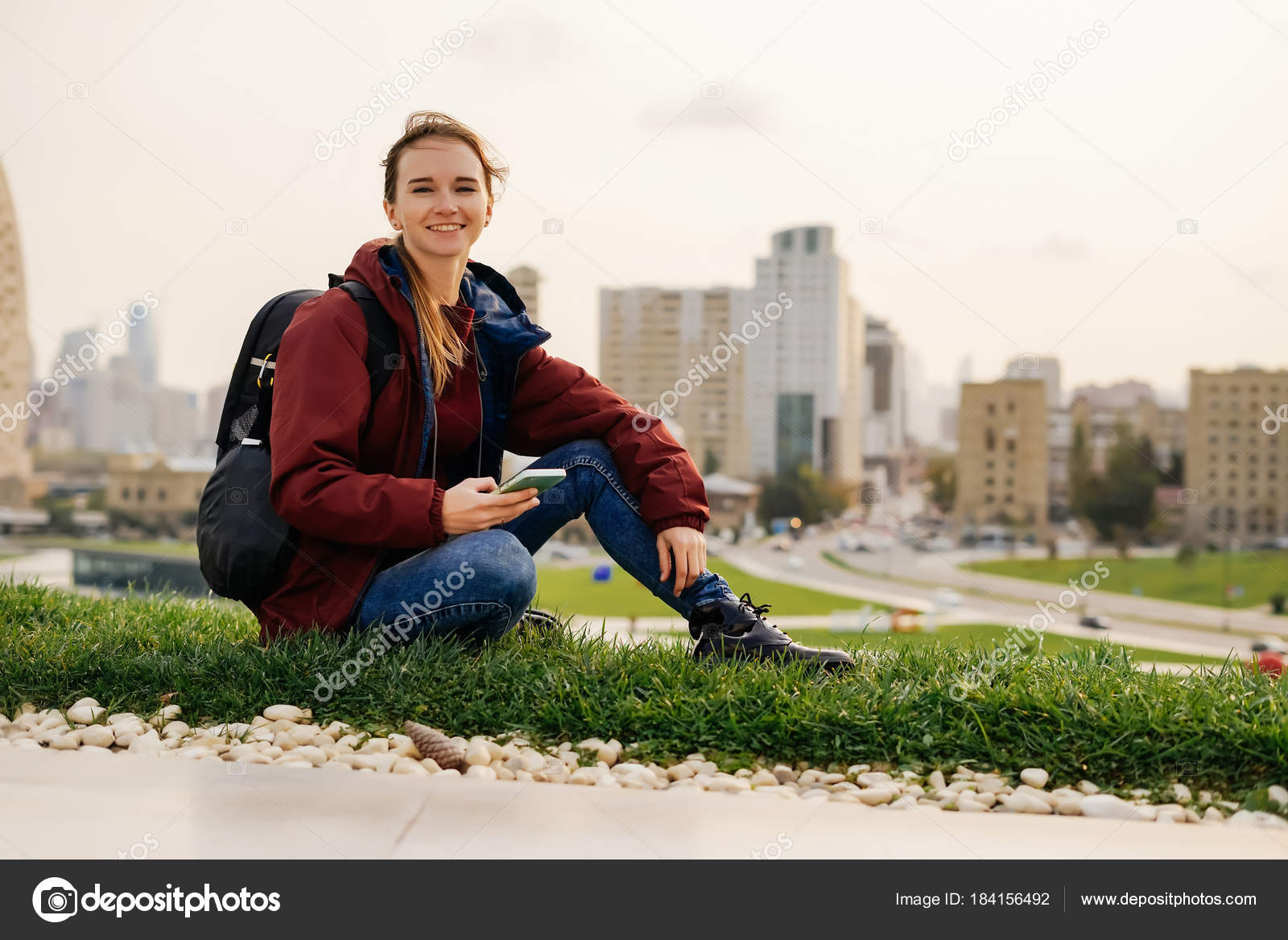 Mujer joven sentada en el banco y mirando la cámara — Foto de stock