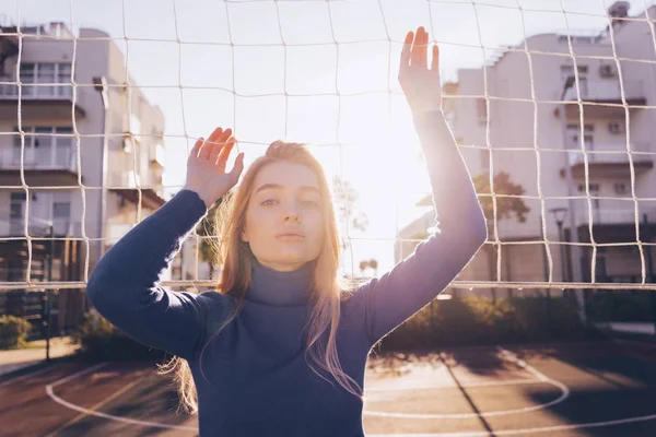 Attraente giovane modella bionda in posa su un campo sportivo al sole — Foto Stock