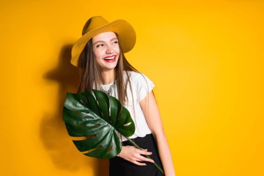 Güzel kız moda bir şapkayla gülüyor yaprak yeşil holding, poz