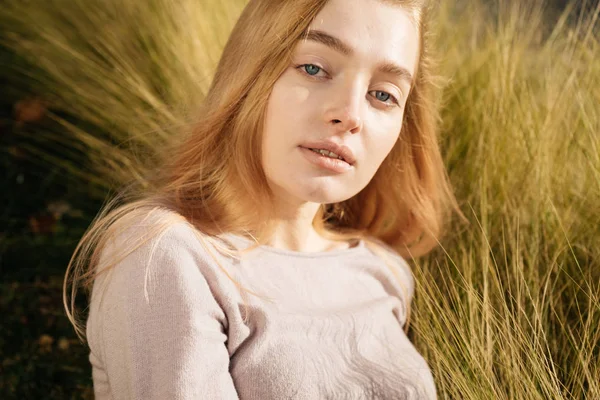 Bonito jovem loira modelo menina encontra-se no campo e posando ao sol — Fotografia de Stock