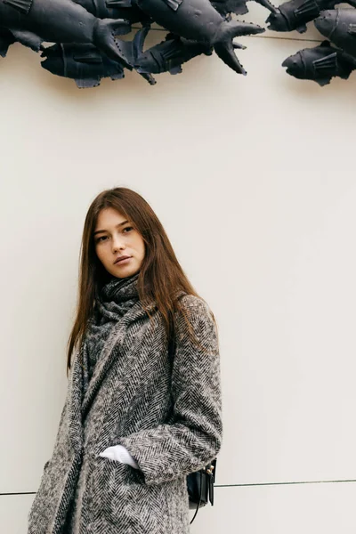 Jeune fille élégante en manteau chaud gris se promenant dans la ville, posant, style de rue — Photo
