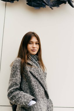 sevimli genç esmer kız gri paltolu şehir poz çevresinde yürüyüş