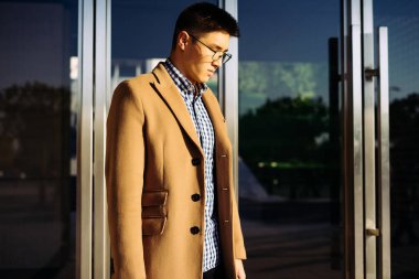 Kendine güvenen Asya delikanlı ile gözlük ve güneş parkta yürüyüş ceket