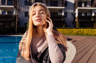 bir şapka giymiş güzel çekici kız ışık kodu ve sarı saçlı güneş, havuzun yanında poz