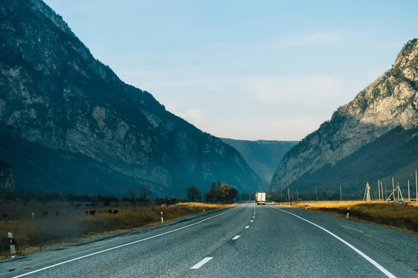 Long highway at the foot of the mountains, an inspiring landscape — Stock Photo, Image