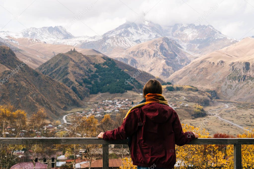 A young girl travels, enjoys a view of the high mountains and clean air