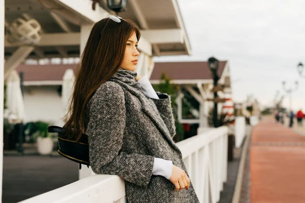 Confiant belle fille élégante dans un manteau gris se promenant autour de la ville, se reposant — Photo