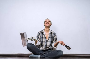 mutlu genç kız onun yeni evinde katta oturur, elinde tutan bir spatula ve fırça
