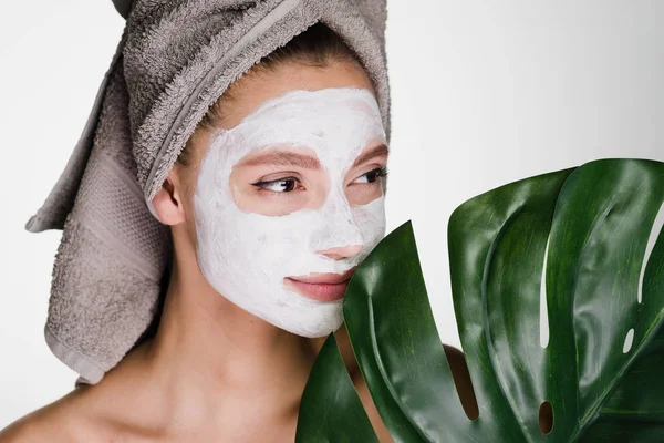 Een jong meisje wil worden mooi, een handdoek op haar hoofd, een hydraterende masker op haar gezicht — Stockfoto