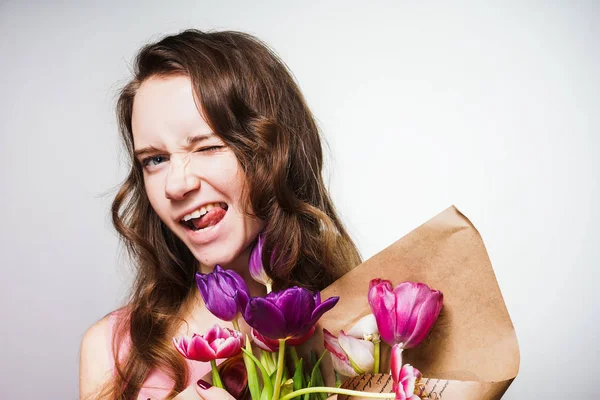 Engraçado feliz jovem segurando um buquê de flores, celebrando o dia das mulheres do mundo — Fotografia de Stock