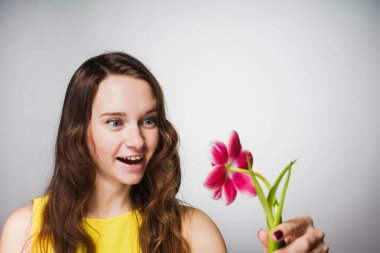 Sarı giysili bir mutlu genç kadına kokulu Pembe çiçek tutan, 8 Mart Dünya Kadınlar günü kutluyor