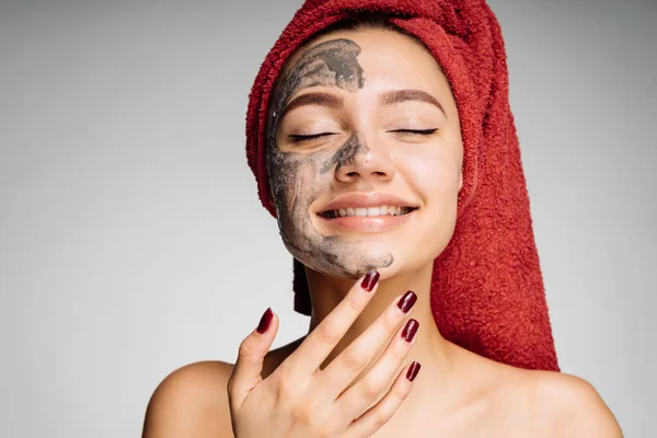 Šťastná mladá dívka s červený ručník na hlavu staví užitečné masku na obličeji, chce být krásná — Stock fotografie