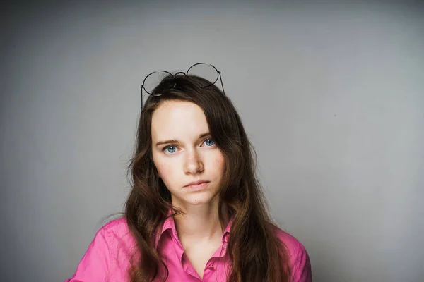 Triste jovem trabalhador de escritório menina em uma camisa rosa olhando para a câmera — Fotografia de Stock