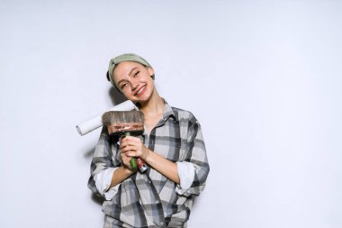 mutlu genç kız yeni bir daire aldım tutan bir rulo ve fırça boyama duvarları, onarım için